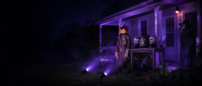 Masks and figures on a porch at night